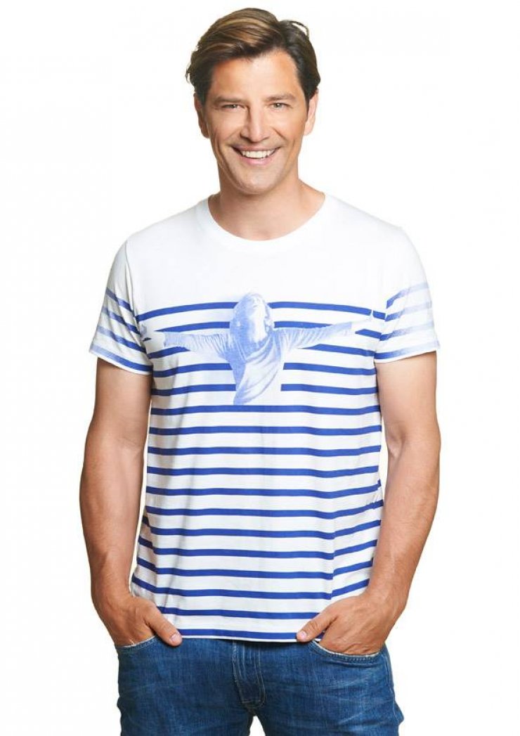 O Σάκης Ρουβάς ποζάρει με το μπλουζάκι του Ιδρύματος Μελίνα Μερκούρη 