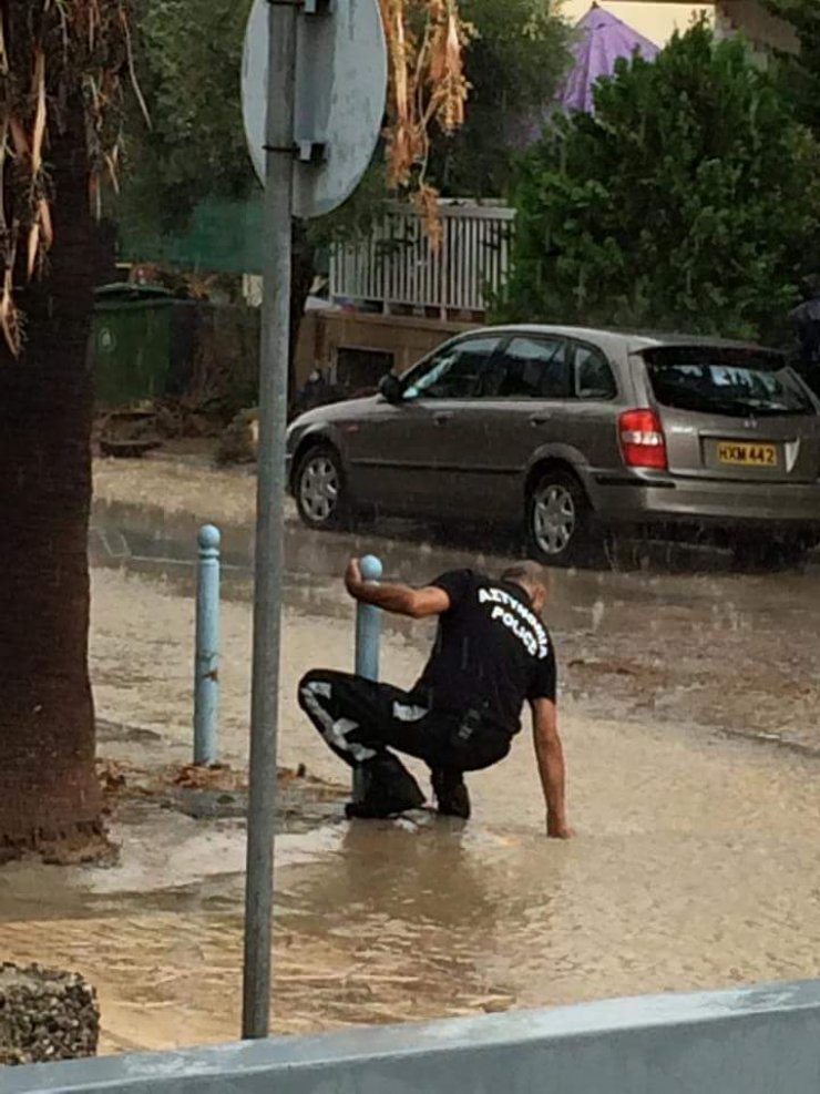 Αστυνομικός αδειάζει φρεάτιο με τα χέρια